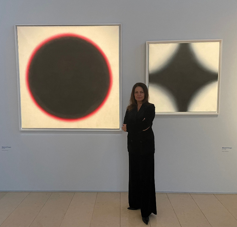 Joanna Piotrowska na tle prac Wojciecha Fangora